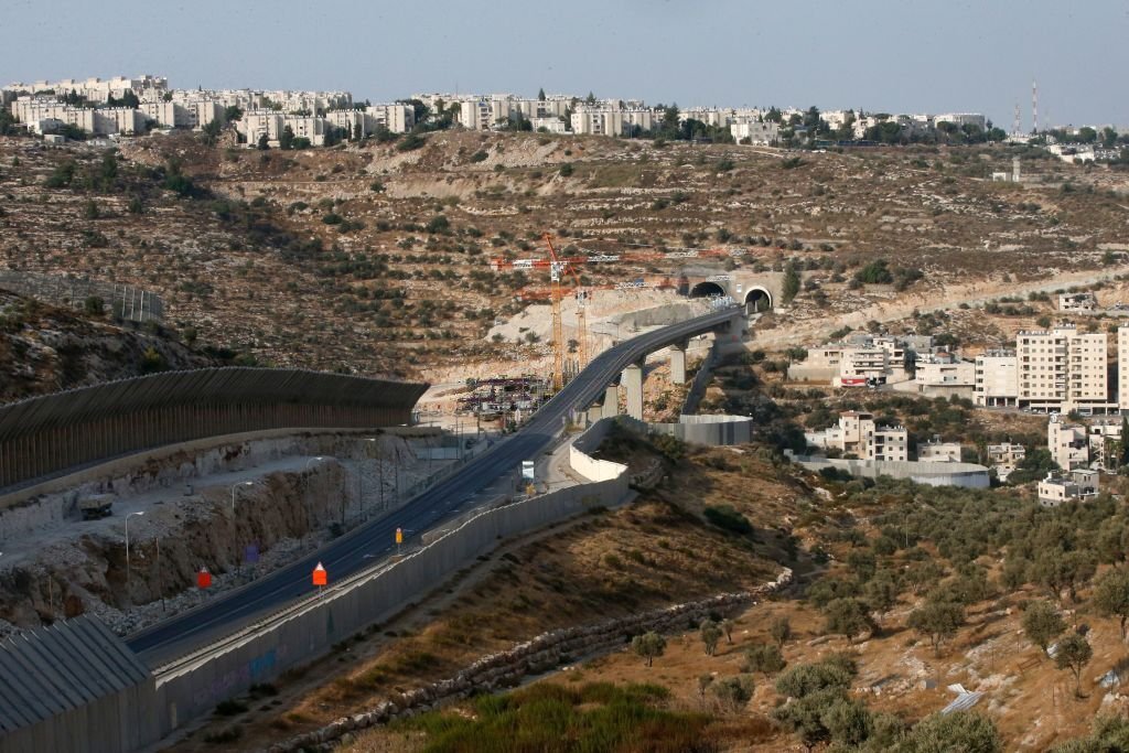 أعمال البناء الإسرائيلي في حفر نفقٍ جديد في الشارع الاستيطاني المعروف بـ"شارع الأنفاق" جنوب القدس، كما تبدو من بلدة بيت جالا، أيلول 2020. (وكالة الصحافة الفرنسية).