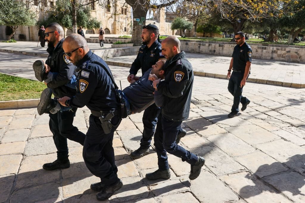 عناصر من شرطة الاحتلال يعتقلون شاباً فلسطينياً ويقتادونه خارج المسجد الأقصى، سعياً لإفراغه من الفلسطينيين لصالح اقتحامات المستوطنين، 5 نيسان 2023. (وكالة الصحافة الفرنسية).