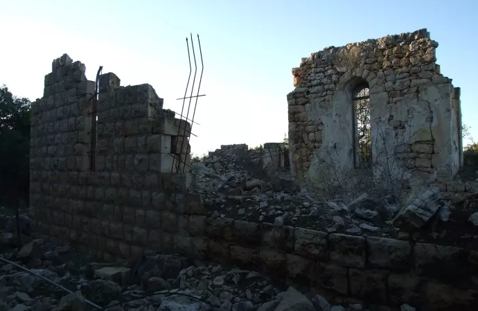 آثار الدمار في كنيسة يوحنا المعدان في قرية المنصورة المهجّرة، شمال شرق عكا. (موقع: فلسطين في الذاكرة),