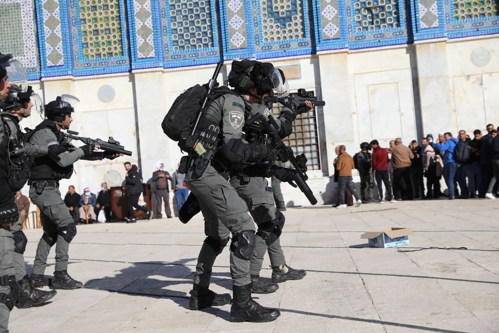 عناصر من شرطة الاحتلال يوجهون بنادقهم تجاه الفلسطينيين في ساحات المسجد الأقصى بعد اقتحامه يوم 15 نيسان/ أبريل 2022. (عمار عوض/وكالة شينخوا الصينية).