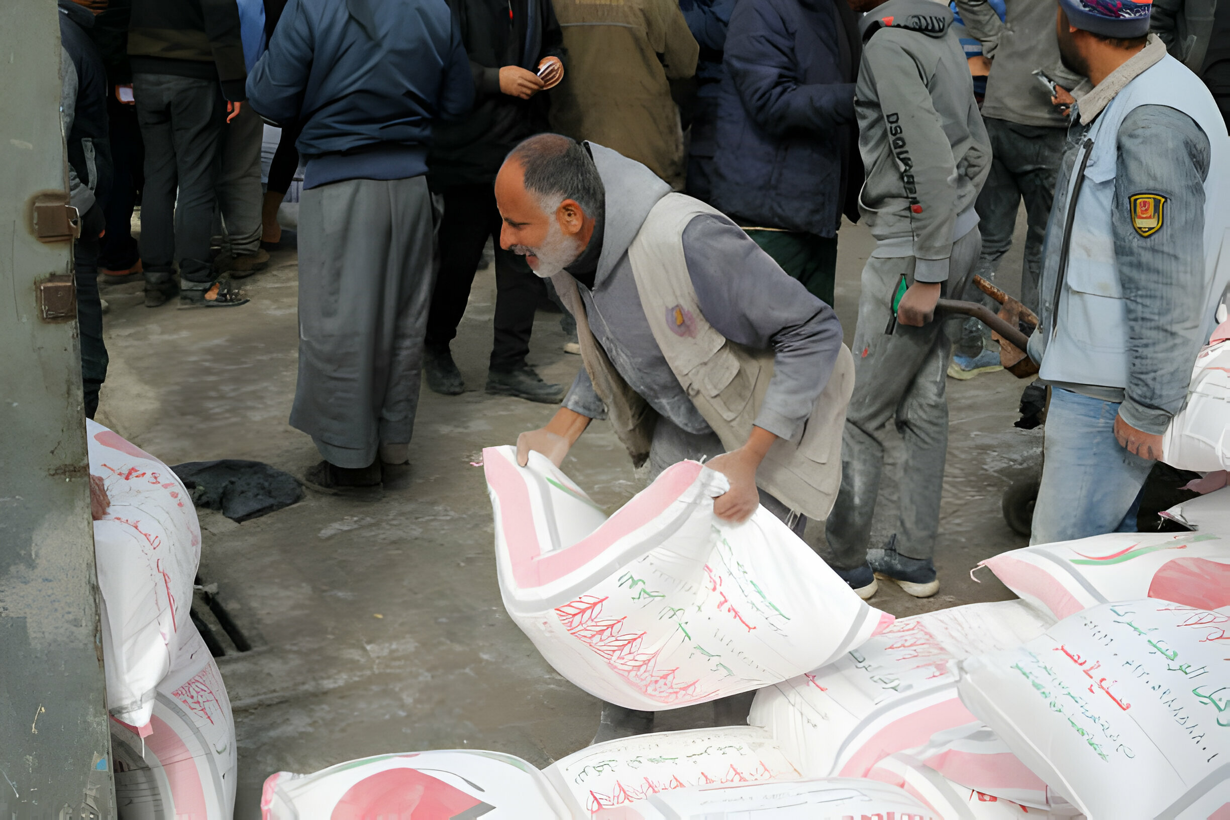 26 كانون الثاني/يناير 2024، فلسطينيون نزحوا إلى رفح يحصلون على أكياس طحين في مركز توزيع تابع للأونروا في المدينة. (عدسة: أحمد زقوت/ وكالة الأناضول).