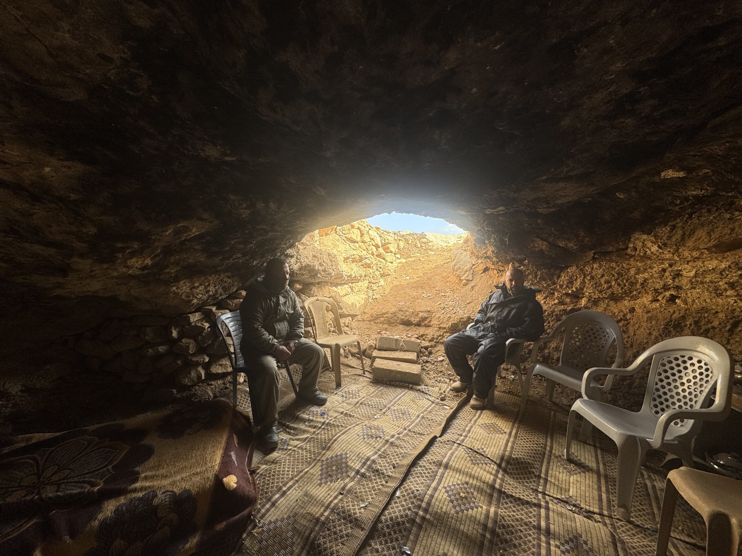 جابر دبابسة وزميله خلال نوبة حراسة قرية خلة الضبع يحتميان داخل مغارة بعد اشتداد الرياح. (تصوير: شذى حماد/ متراس)