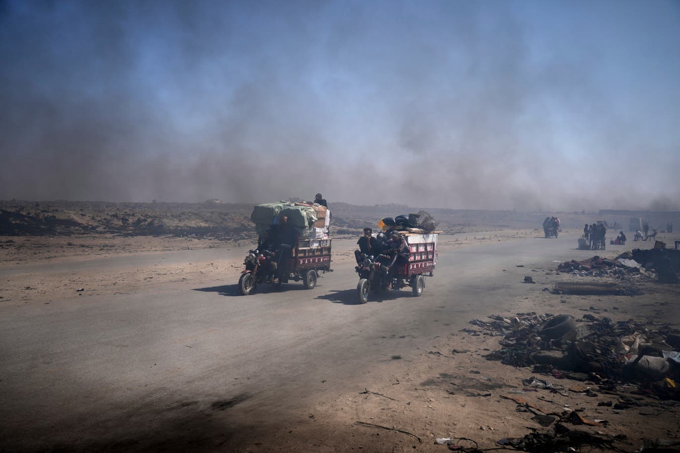 الدخان الأسود المتصاعد من المواقد التي يتم فيها حرق النفايات البلاستيكية لإنتاج الوقود، حيث ينتشر جنوبي مدينة غزة وبين خيام الناس. (تصوير: عبد الكريم حنا/ وكالة أسوشيتد برس) 
