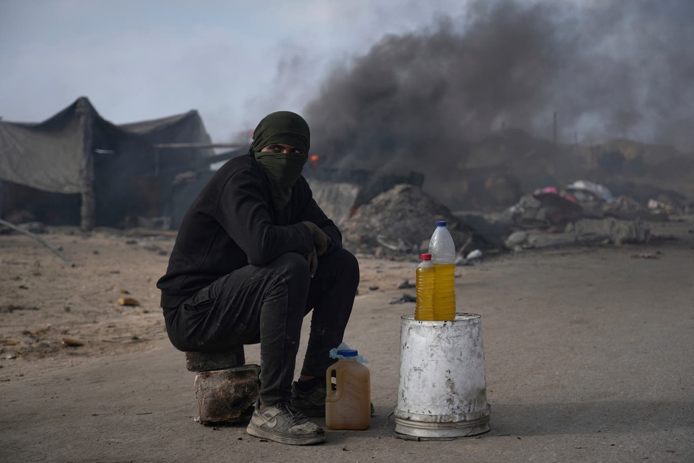فلسطيني يبيع الوقود الناتج عن عملية صهر البلاستيك في مواقد بدائية جنوبي مدينة غزة، نظراً لمحدودية توفر الوقود، في 24 حزيران/ يونيو 2025. (تصوير: عبد الكريم حنا/ وكالة أسوشيتد برس)