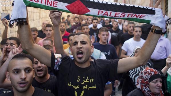 فلسطيني يهتف بشعارات وهو يحمل وشاحاً كُتب عليه فلسطين خلال مظاهرة احتجاجاً على العدوان الاحتلال على قطاع غزة في 28 تموز/ يوليو 2014، أمام المسجد الأقصى. (المصدر: وكالة فرانس برس/أحمد غرابلي)