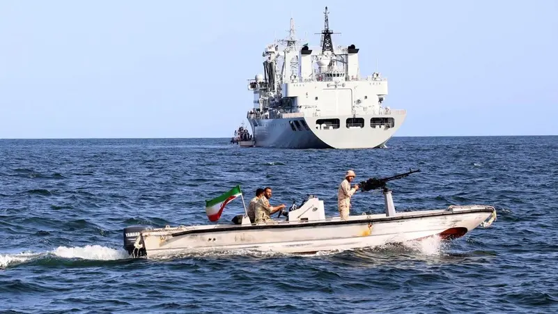 صورة نشرها الجيش الإيراني في 12 آذار/ مارس 2024، يظهر زورق عسكري إيراني يقوم بدورية بينما تدخل سفينة حربية المياه الإيرانية قبل بدء مناورة بحرية مشتركة بين إيران وروسيا والصين في المحيط الهندي. (المصدر: أسوشيتد برس)